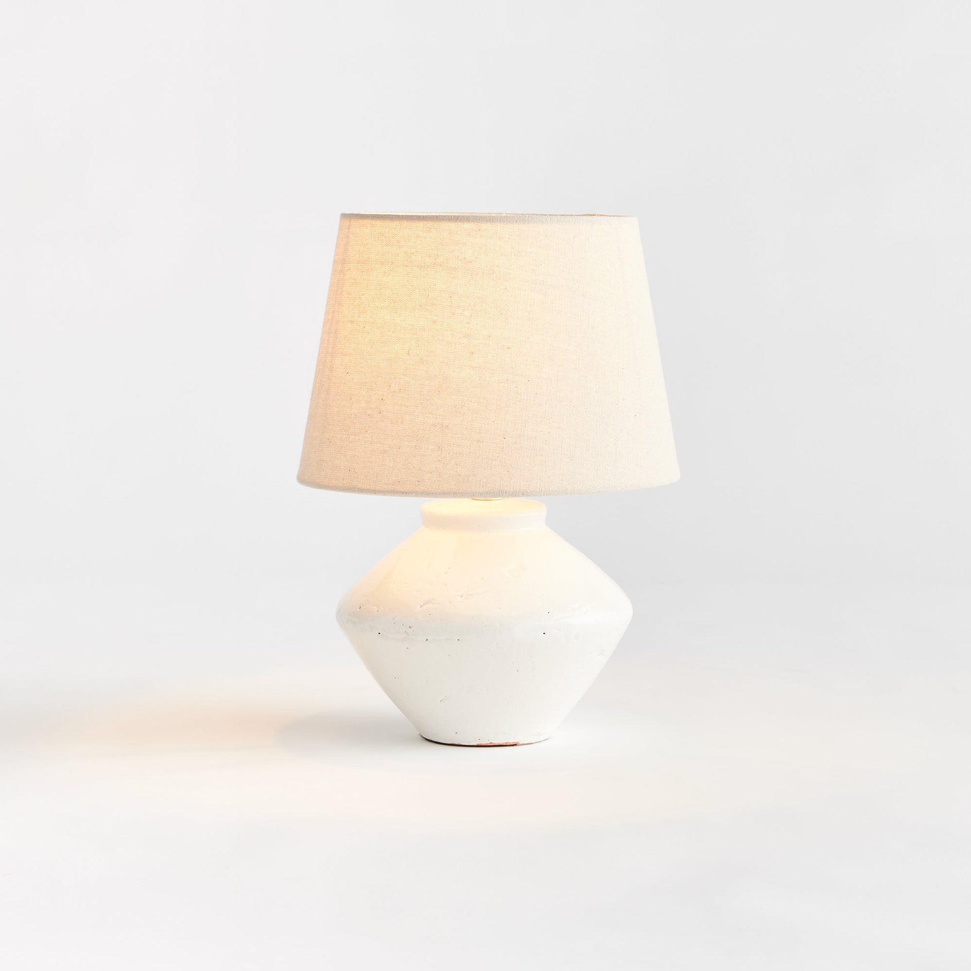 Expertly crafted from high-quality ceramic, this mini table lamp is the perfect addition to any transitional setting. Its petite base and textured cream/beige shade make it a versatile piece, ideal for accentuating kitchen counters, bookshelves, or desks. Featuring an in-line switch and a beige linen shade, this lamp combines style and functionality seamlessly.