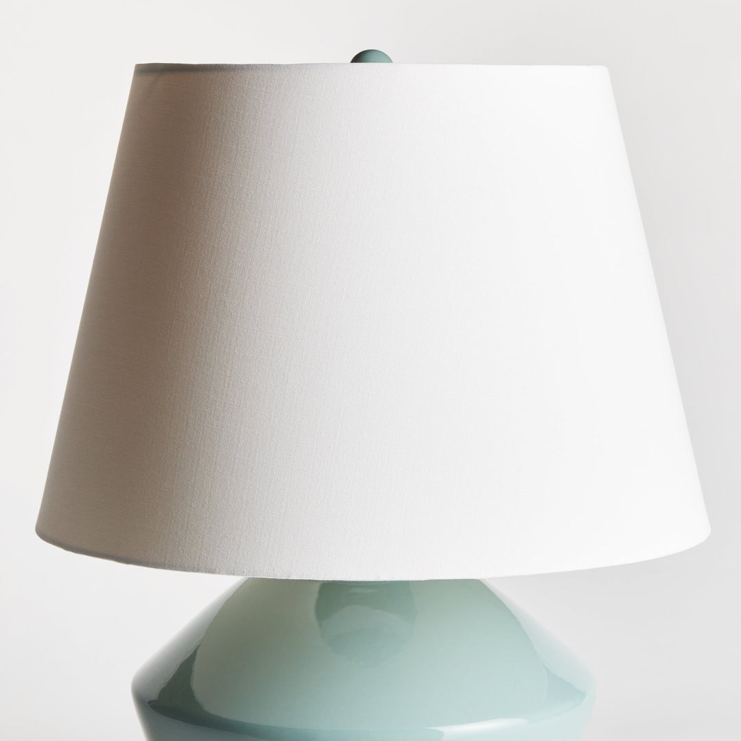 Crafted with an ancient wooden mold, the Clyde Celadon Table Lamp showcases a timeless design and stunning celadon finish. Its fabric shade adds character and charm to spaces such as family rooms, studies, and bedrooms.