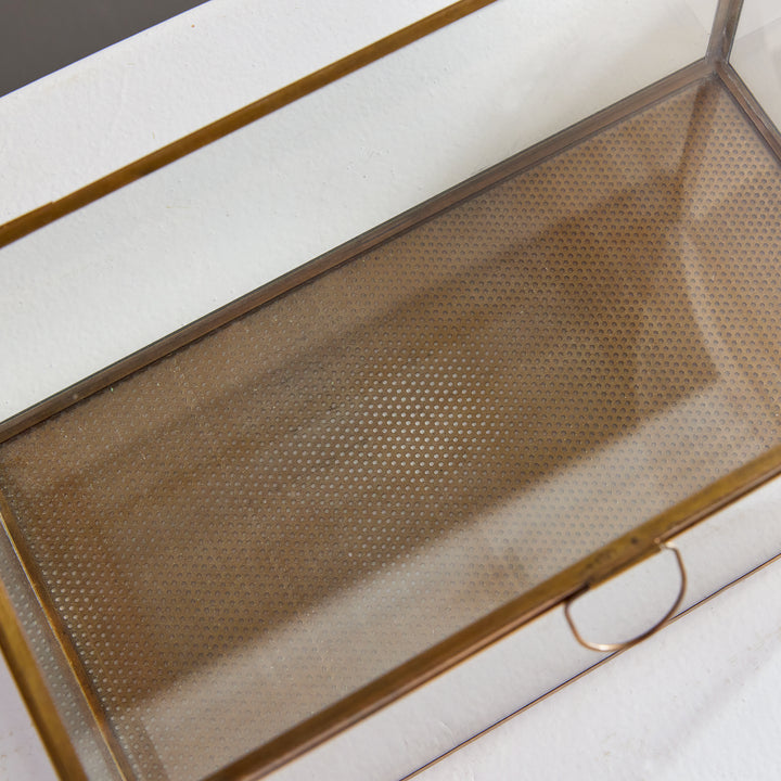 Expertly crafted with a combination of glass and brass, the Arwen Rectangular Antique Brass Display Box is designed to securely hold and protect your most cherished mementos. A sleek loop handle prevents fingerprints from marking the glass, keeping your keepsakes pristine.