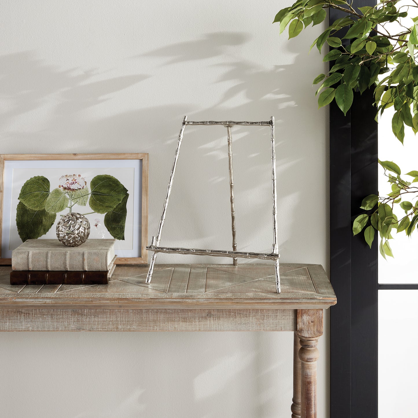 This Silver Easel Large is designed to hold platters, cookbooks, or a small piece of art with its sturdy and strong structure. Its traditional aesthetics and bamboo-like accents lend a professional and sophisticated look. It is a functional and visually appealing piece that can display your favorite items or provide practical storage in your home. Experience the best of both worlds with this versatile easel.