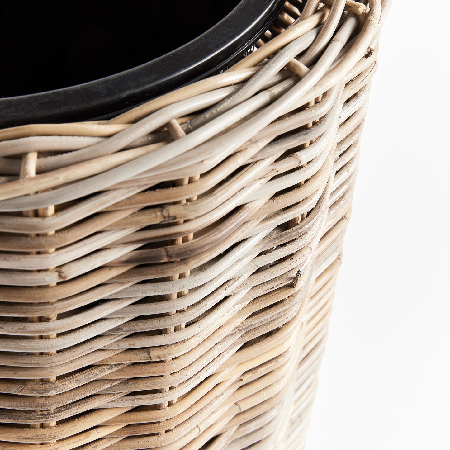 Crafted with all-natural materials, this rattan planter boasts a distinctive flattened weave design and is complemented by a sturdy iron frame and included grower's pot. Perfect for those seeking a durable and aesthetically pleasing option.