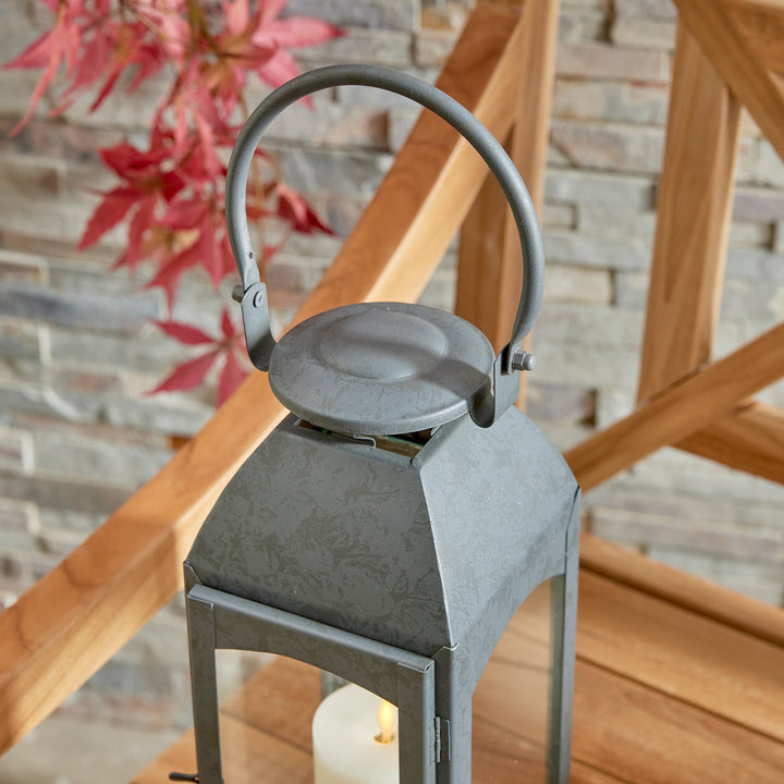 Crafted with a chic faux zinc finish and soft grey tone, this outdoor lantern brings a touch of old European style to your outdoor space. Its vintage-inspired design is true to the authentic qualities of the lantern, perfect for creating a sophisticated ambiance. Enhance your outdoor decor with the Antoinne Outdoor Gray Lantern Small and add a charming European touch.