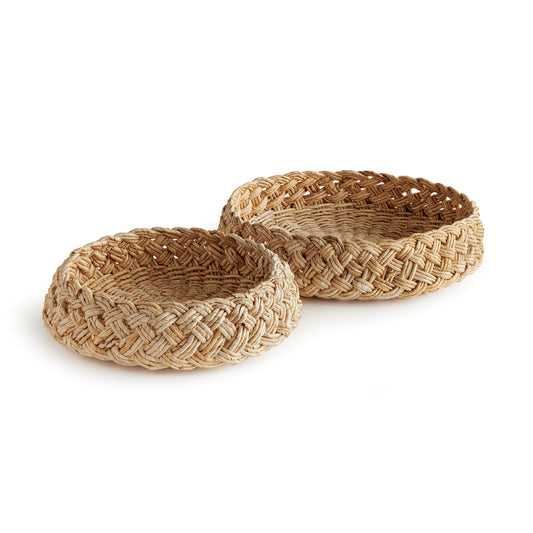 Made from abaca, a sustainable banana material, these baskets are expertly crafted by skilled artisans using a French braiding technique to create a durable and visually unique product. Perfect for wide open spaces, this set adds a touch of elegance to any room and can be used as decorative pieces on large surfaces such as ottomans, consoles, or side tables.