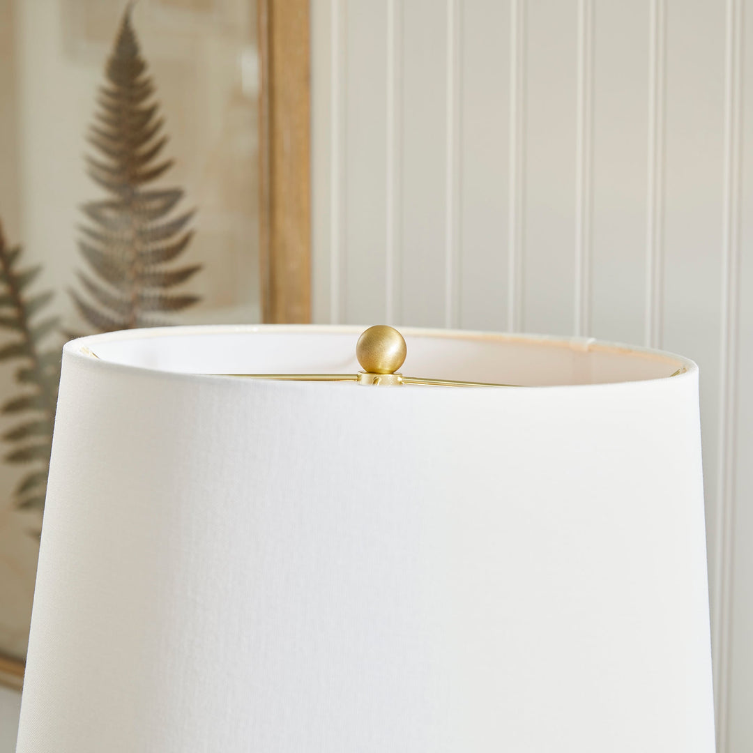 With a pressed pattern on the ceramic body, the Nadia Lamp is a work of art. Topped off with a generously scaled fabric shade, it is sure to enhance any space. intricate details, bold, finial, classic white, metal accents This ceramic lamp boasts an eye-catching pressed pattern and an elegantly designed fabric shade, making it an artistic addition to any room. With intricate details, a bold finial, and classic white coloring with metal accents, it offers both style and subtlety.