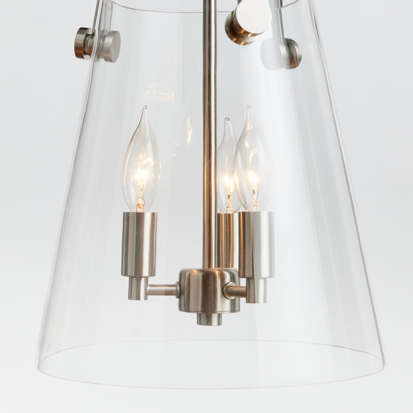 Crafted from a custom glass mold, the Capra Silver Chandelier Light Small boasts a perfectly proportioned design. An innovative touch is the top silver metal detail that extends through the glass, resulting in a distinctive appearance. This chandelier is also compatible with sloped ceilings and meets CAL Green compliance standards for versatility and sustainability.