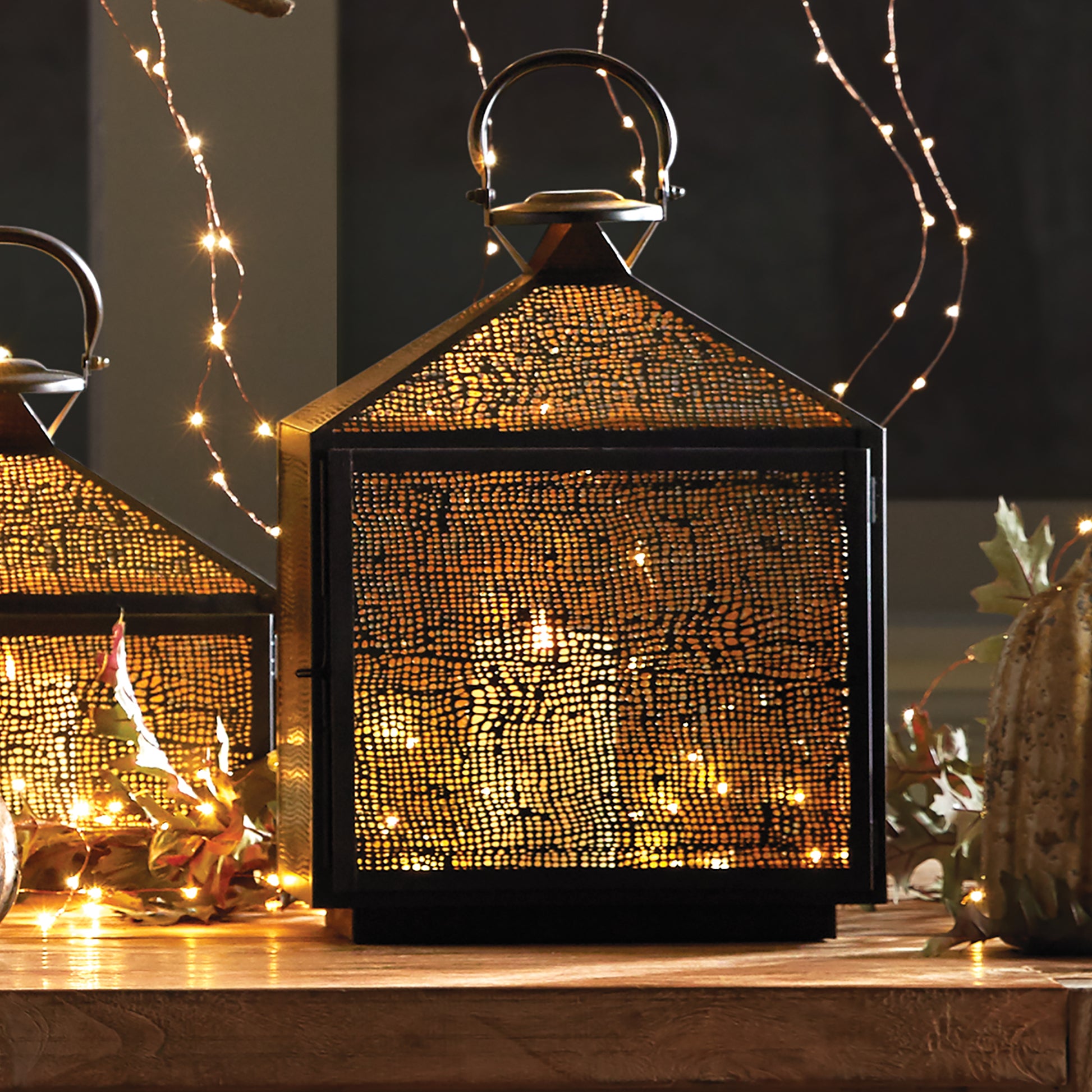 The Amhurst Indoor Lantern Medium boasts an intricate mesh pattern that diffuses candlelight with expert precision. Its golden brass interior adds a touch of elegance to the warm glow, making it a stunning addition to any indoor area.