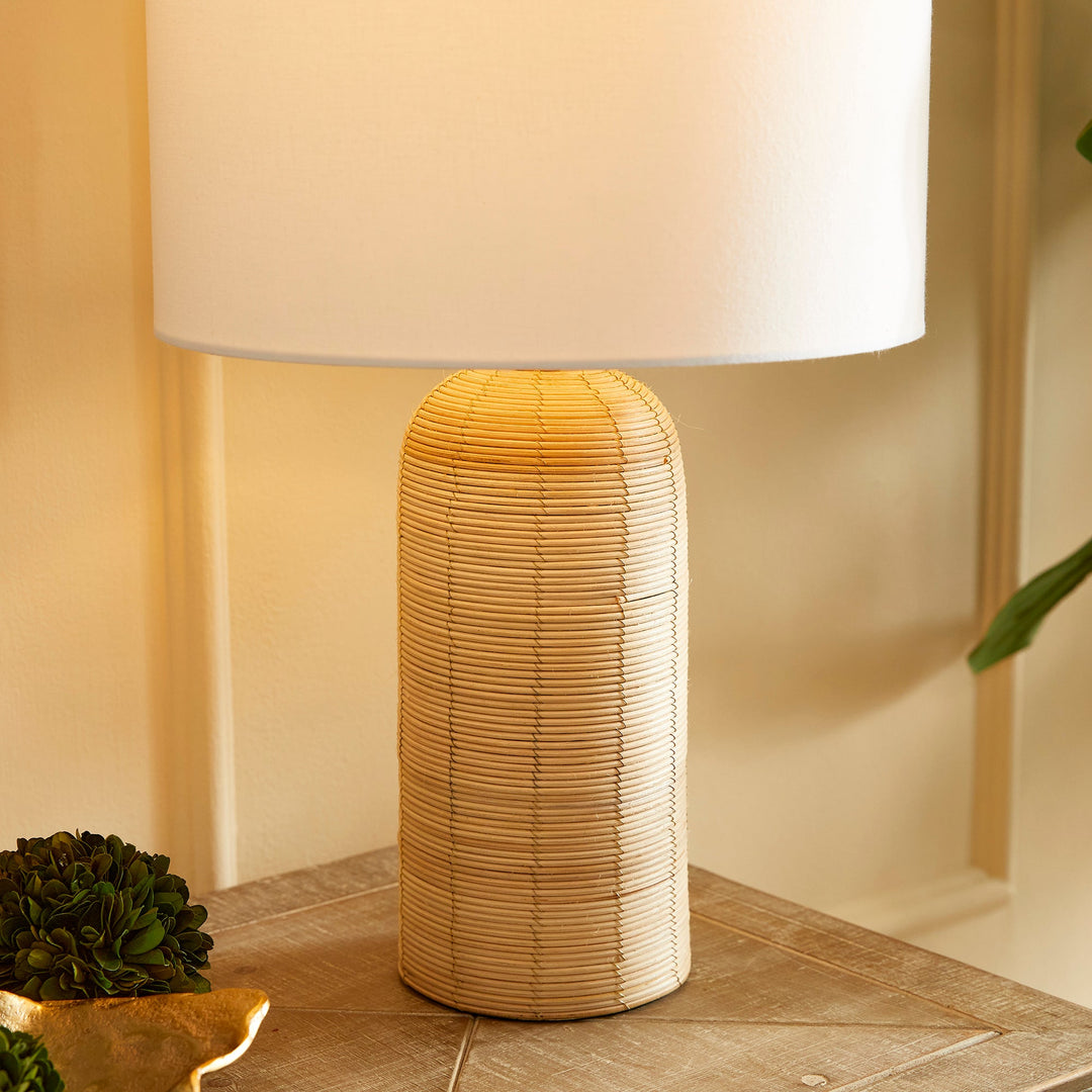 Crafted with a whitewashed cane rattan weave, this table lamp boasts individuality with its varying colors. It's a timeless piece, featuring a wide cylindrical shade that effortlessly complements any room, be it a bedroom, living room, or study.