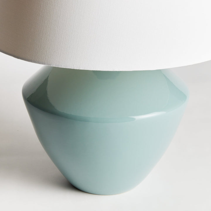 Crafted with an ancient wooden mold, the Clyde Celadon Table Lamp showcases a timeless design and stunning celadon finish. Its fabric shade adds character and charm to spaces such as family rooms, studies, and bedrooms.