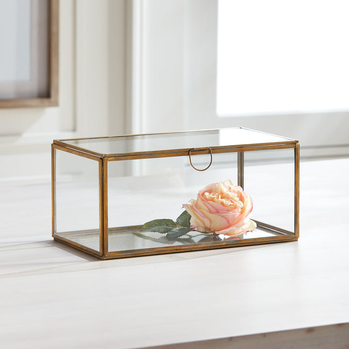 Expertly crafted with a combination of glass and brass, the Arwen Rectangular Antique Brass Display Box is designed to securely hold and protect your most cherished mementos. A sleek loop handle prevents fingerprints from marking the glass, keeping your keepsakes pristine.