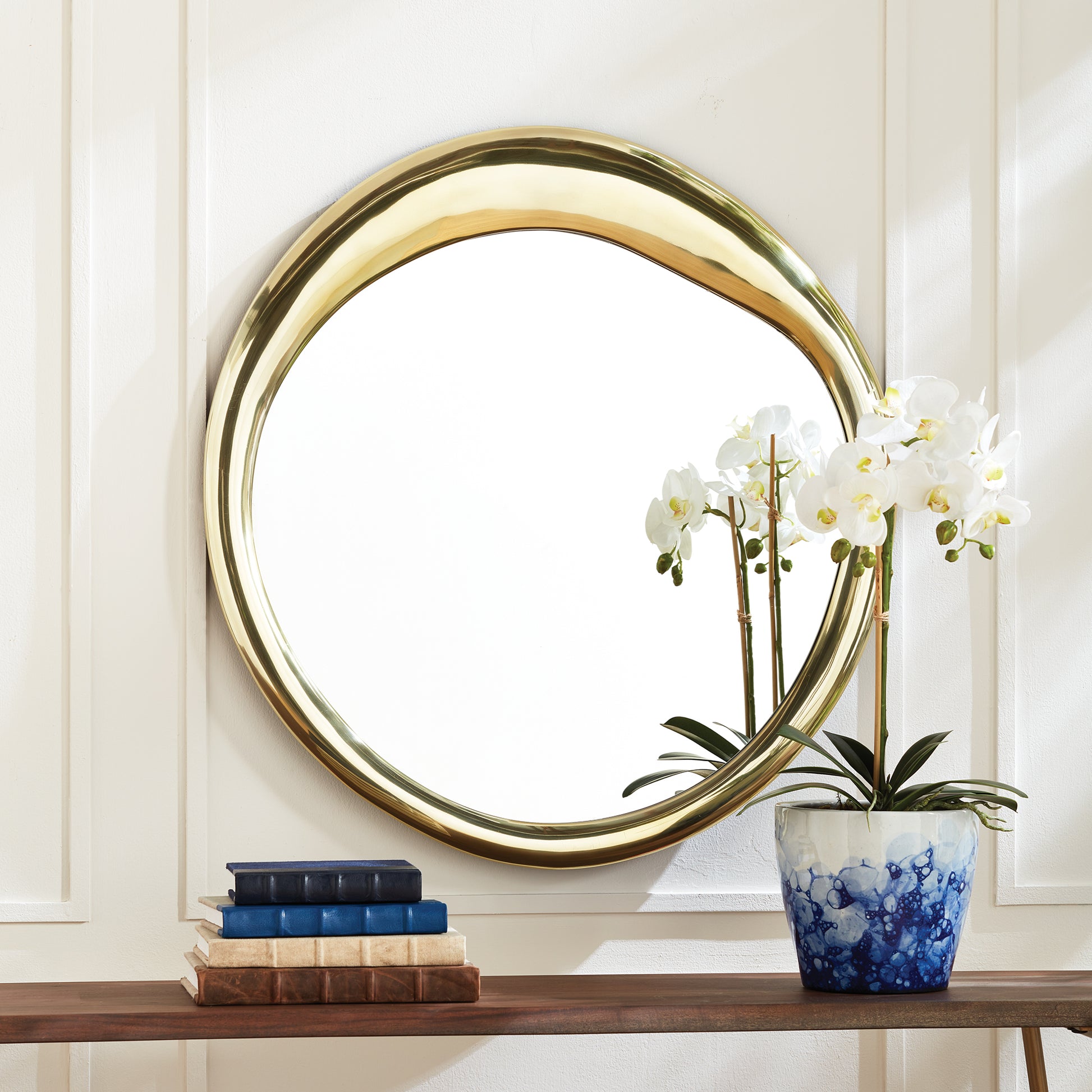 Crafted with precision and featuring a one-of-a-kind, meandering design, the Ainsley Gold Modern Wall Mirror seamlessly combines function and artistry. With included hanging hardware for adaptable installation, this mirror is a versatile addition to any modern home. Whether in a foyer, powder room, or hallway, this mirror showcases expert craftsmanship and impressive design, elevating the aesthetic of any space.