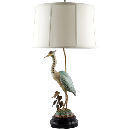This sophisticated porcelain heron table lamp adds a touch of elegance to any living room. Featuring natural tones and a beautiful bird statuary, this lamp is adorned with a bronze ormolu and paired with a complementary lamp shade. Perfect for adding a unique touch to your home decor.