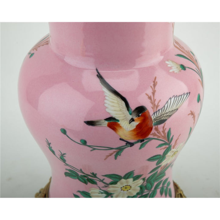 Introducing the Khom Pink Floral Pattern Vase, adorned with delicate flowers and birds. Made of high-quality porcelain with bronze accents, this decorative vase adds elegance to any living room or garden collection. Expertly crafted for a timeless and beautiful addition to your home.