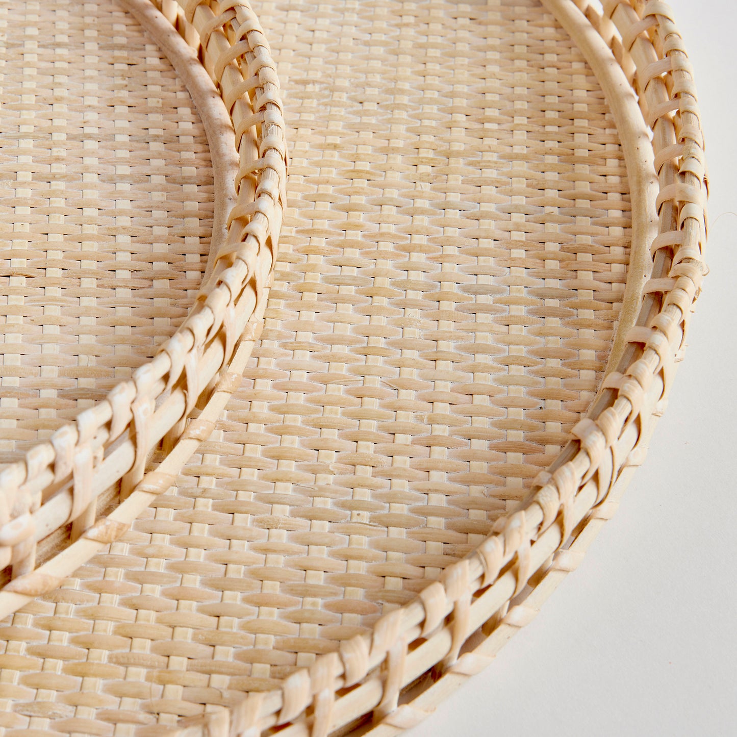 Crafted from woven rattan and coated with a fresh whitewash finish, these coastal-inspired trays add a touch of charm to any space. Use them on your coffee table or ottoman as a stylish base for creating beautiful vignettes. Enhance your home decor with Barri Coastal Decorative Trays Set of 2.