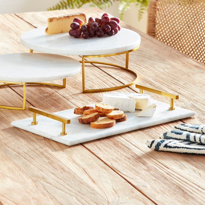 This Marble Serving Tray features a timeless pairing of marble and brass, making it the perfect way to present your favorite cheese and cracker platters. Its versatile design is suitable for coastal, traditional, and transitional settings, elevating your hosting game with a touch of sophistication. Whether you're serving a decadent cheese platter or a simple cracker spread, this tray is sure to impress, adding an elegant touch to any occasion.