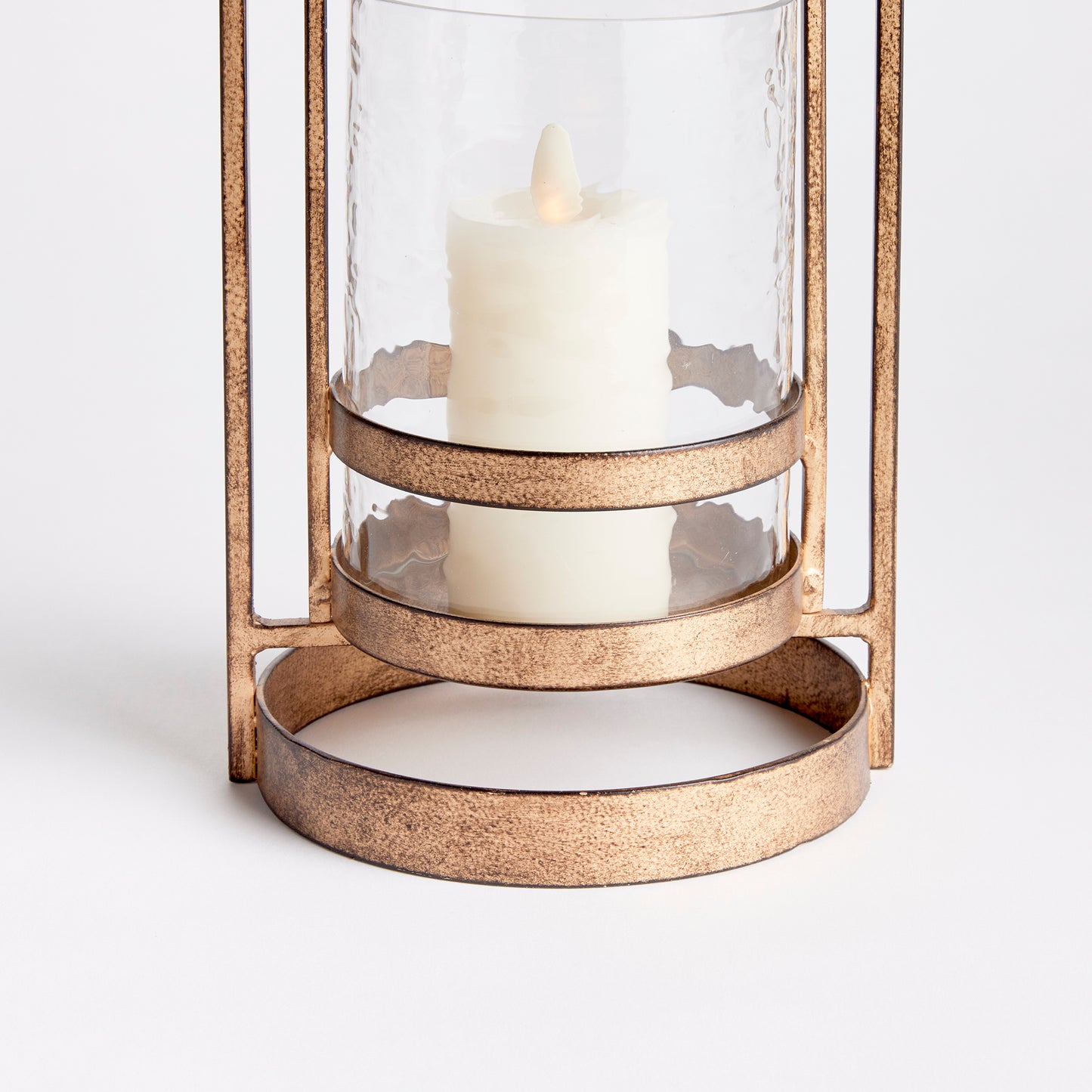 Crafted with precision from sturdy cast aluminum and adorned with exquisite hammered glass, the Amara Gold Hurricane Candle Holder Small showcases a perfect balance of lyrical form and substantial design. A decorative yet functional loop handle completes the look, making it a versatile addition to any transitional or modern setting.