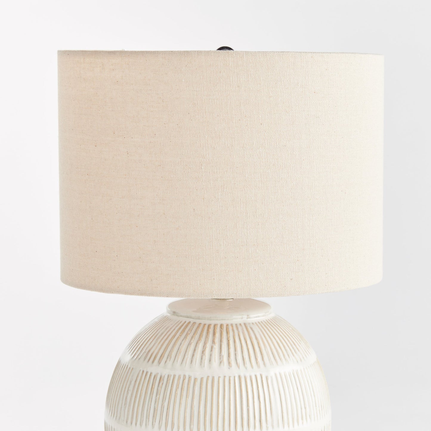 Featuring a rounded ceramic body with a hatch mark pattern, the Antoni White Table Lamp brings character to any space. The natural linen shade serves as a lovely accent on a bedside table, side table, or desk in a living room or dining area.