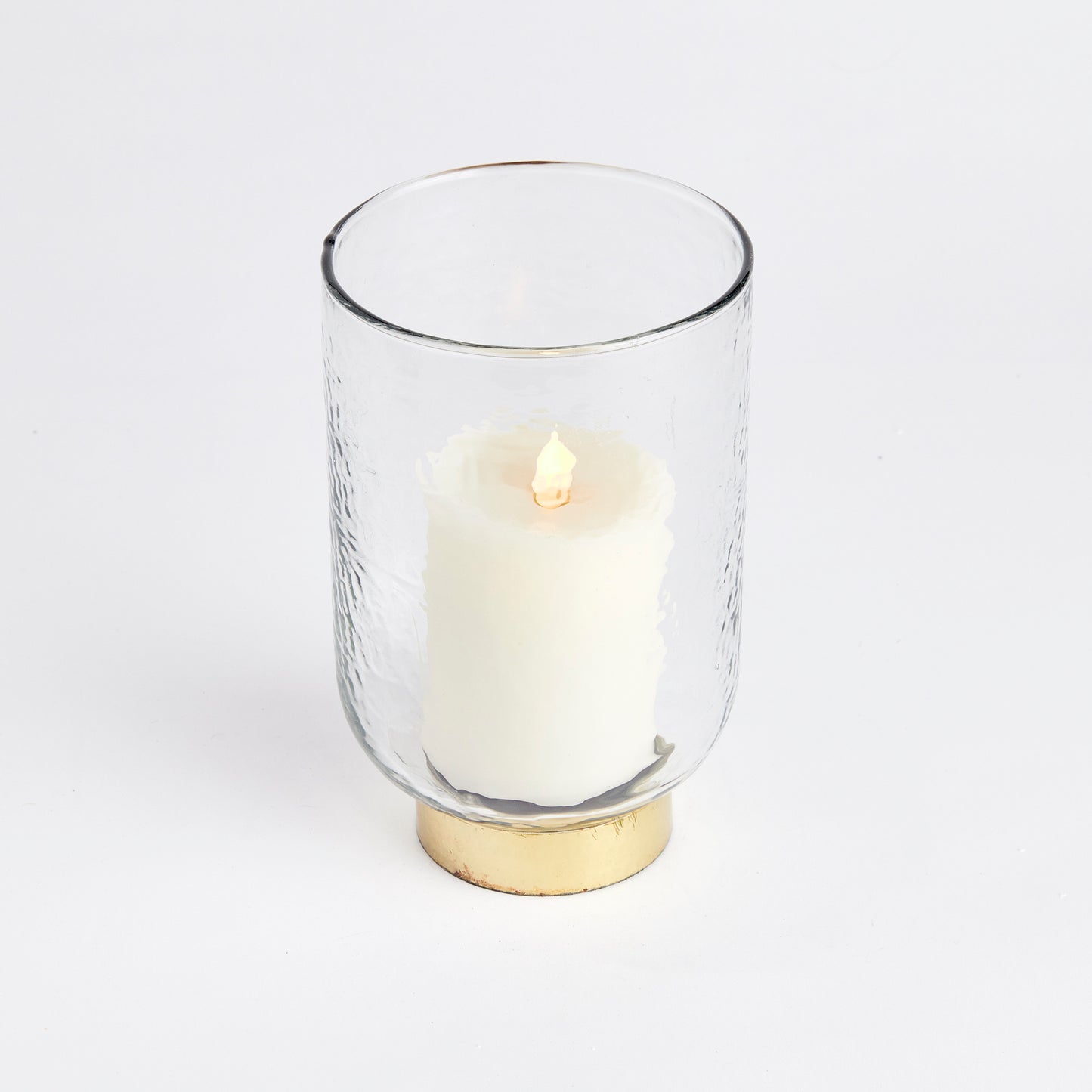 Featuring a thick, hammered glass and a unique melted uneven edge, the Amira Gold Hurricane Medium Candle Holder adds an artisanal touch to any space. Its finishing touch is the elegant hammered gold rim base, making it a sophisticated accent for console, bookshelf, or mantel. Crafted with expert skill, this hurricane is a true testament to fine craftsmanship.