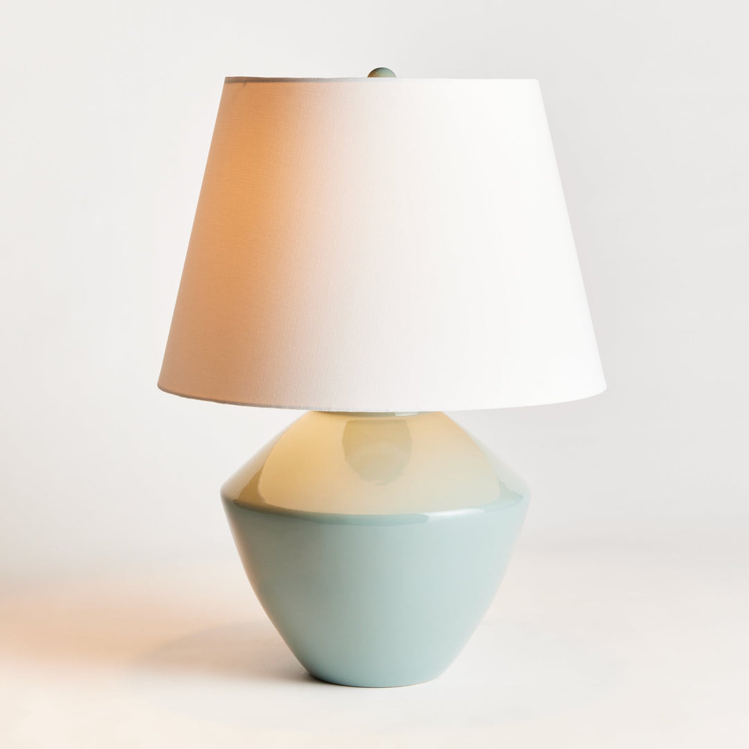 Crafted with an ancient wooden mold, the Clyde Celadon Table Lamp showcases a timeless design and stunning celadon finish. Its fabric shade adds character and charm to spaces such as family rooms, studies, and bedrooms.