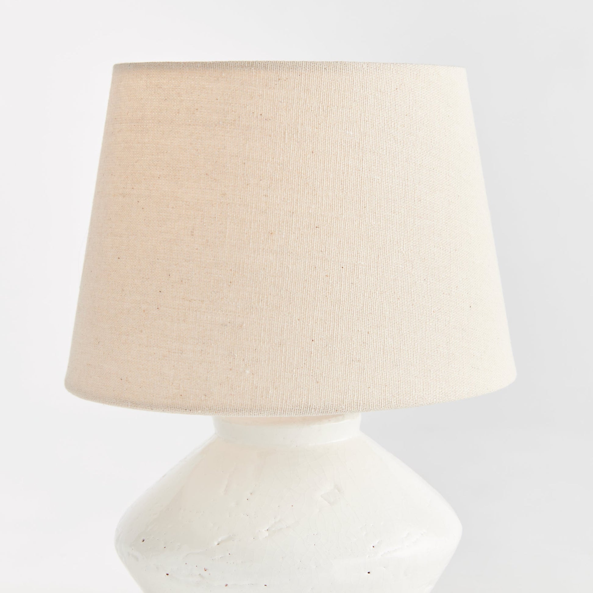 Expertly crafted from high-quality ceramic, this mini table lamp is the perfect addition to any transitional setting. Its petite base and textured cream/beige shade make it a versatile piece, ideal for accentuating kitchen counters, bookshelves, or desks. Featuring an in-line switch and a beige linen shade, this lamp combines style and functionality seamlessly.