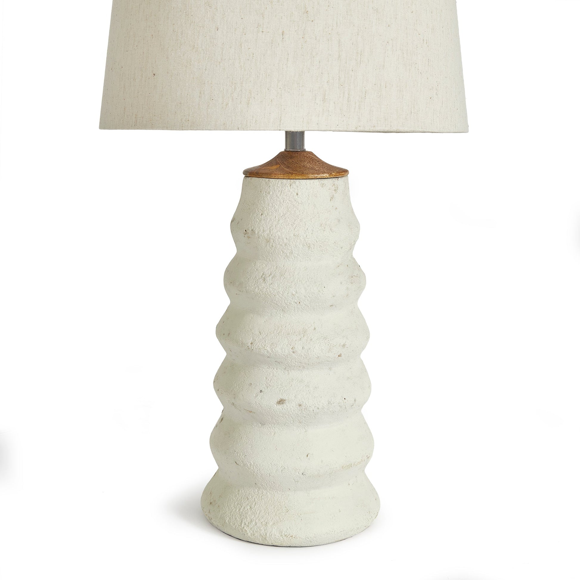 Enhance your living area with the Adria Table Lamp. This elegant table lamp features a natural cream eco-mix with a unique pitted texture, creating a lasting and warm white glow. The tapered shade adds a touch of sophistication to any living room.