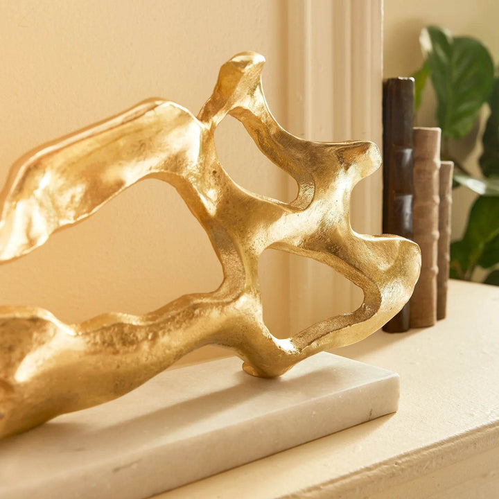 Enhance your coastal design with this striking abstract sculpture inspired by driftwood. Resting on a sleek white marble base, creating an elevated and luxurious atmosphere. This one-of-a-kind sculpture adds a sophisticated touch to any living space, expertly crafted with a unique driftwood-inspired design. Perfect for displaying on a shelf or table, it adds an upscale and polished touch to your coastal decor.