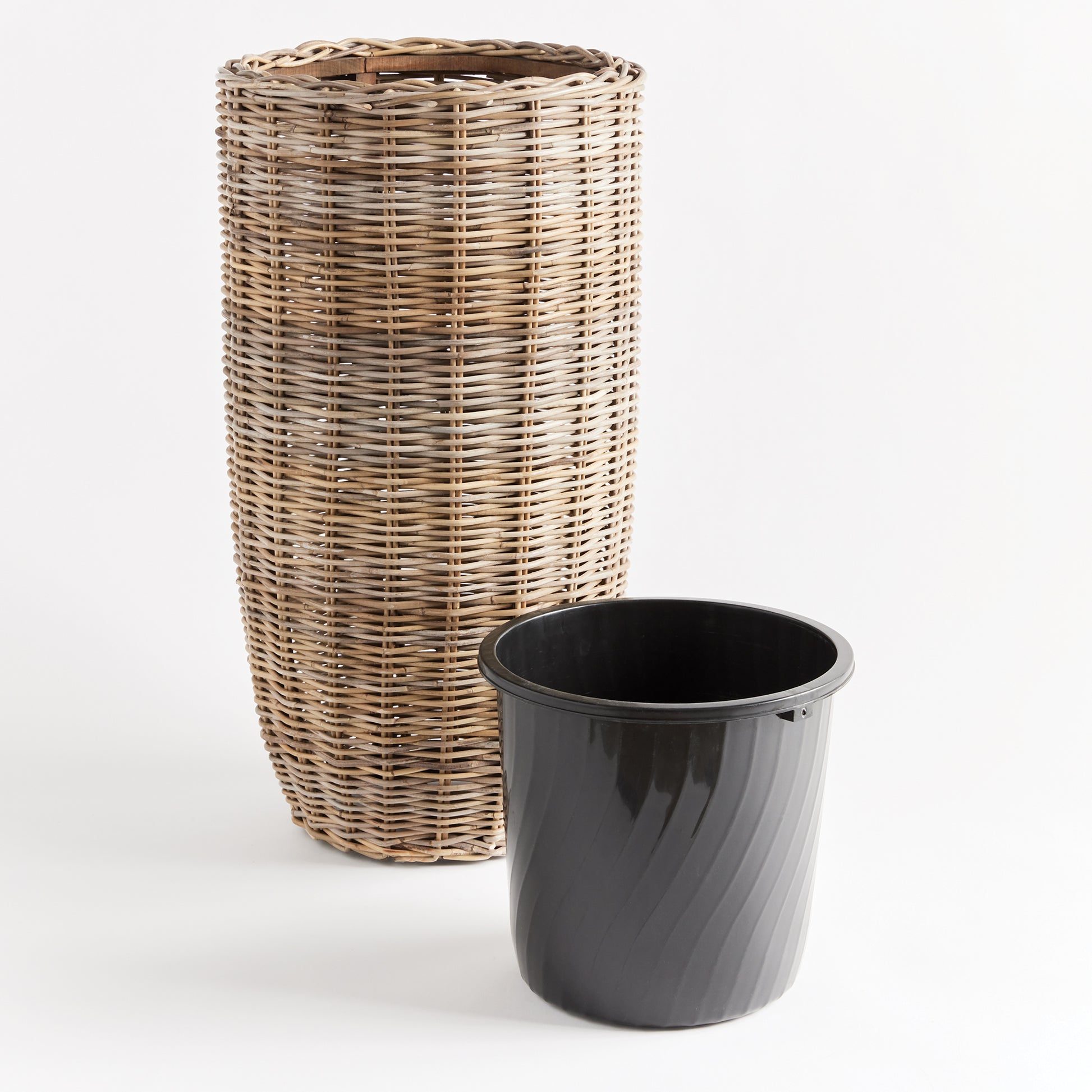 Crafted with all-natural materials, this rattan planter boasts a distinctive flattened weave design and is complemented by a sturdy iron frame and included grower's pot. Perfect for those seeking a durable and aesthetically pleasing option.