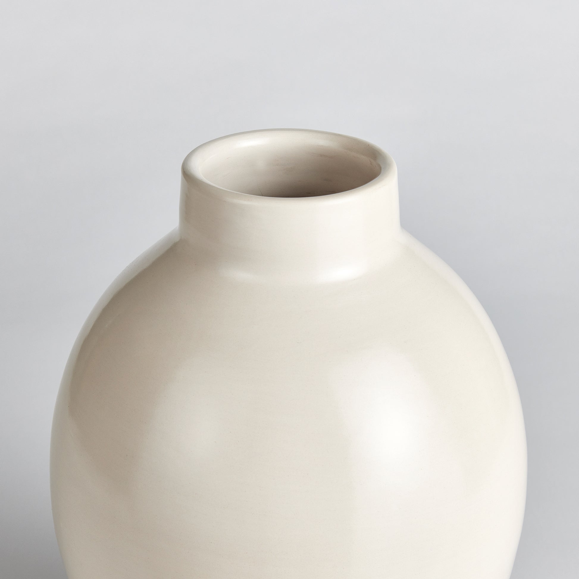 This exquisite ceramic vase is artfully crafted using traditional techniques from Chulucanas, Peru. The warm climate and ancient Incan methods contribute to its exceptional quality and the artisan's touch adds an authentic element. Through a wire pad buffing technique, a subtle texture is created, and a unique ecru pigment is carefully applied during the firing process. This results in a durable, long-lasting piece that brings a touch of warmth and charm to any space.