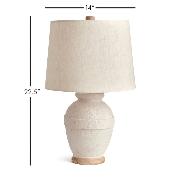 This table lamp features a composite base made of natural Eco mix, incorporating hardening agents for long-lasting durability. The warm white finish adds a subtle texture, showcasing the unique composition of the material. Topped with a linen tapered shade and banded silhouette, this petite lamp is perfect for bedside tables or desks. Designed with sustainability in mind, it utilizes an Eco mix made from natural materials, combining durability with eco-friendliness.