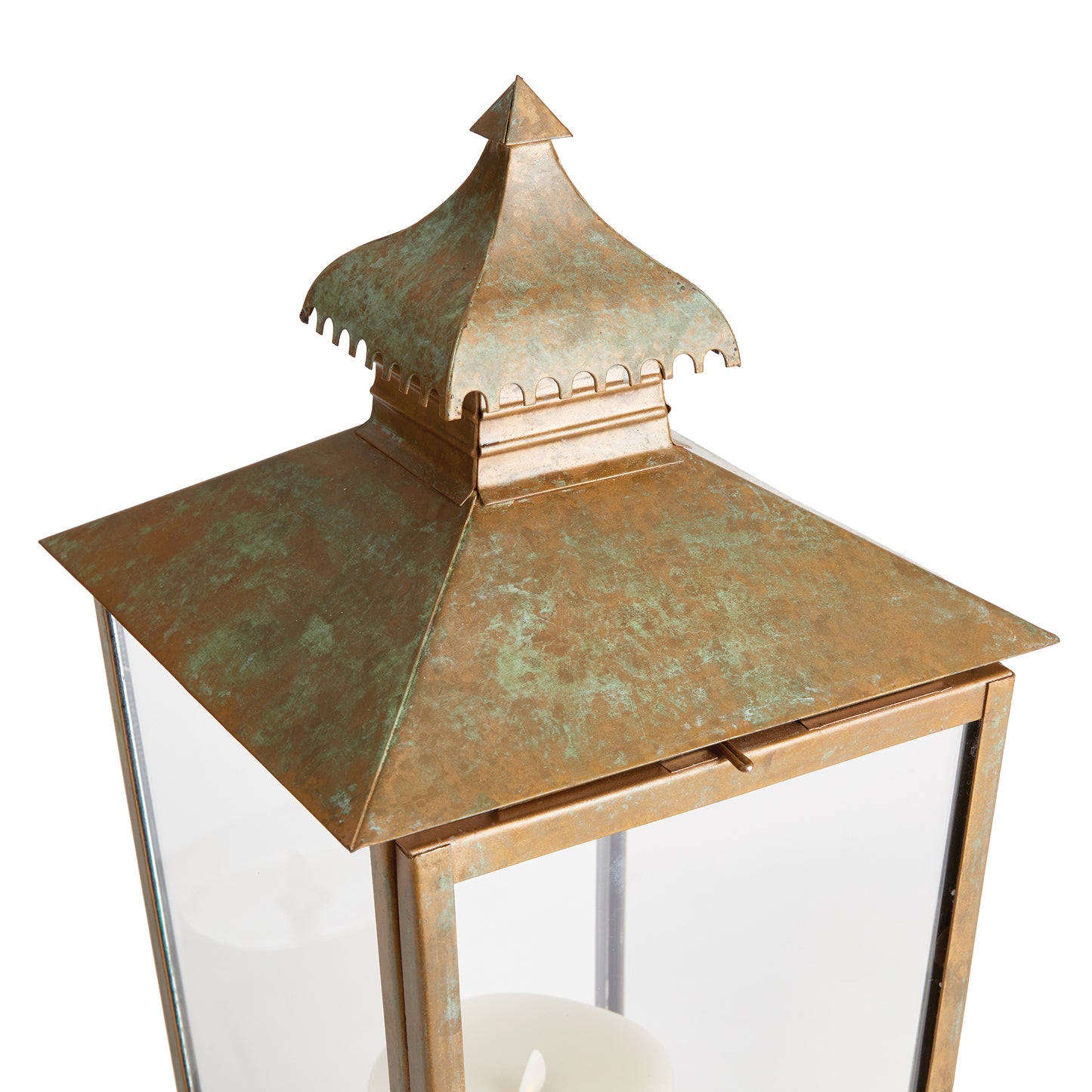 This lantern's design is characterized by a curved pagoda and a notched edge, adding to its simple yet distinctive look. The warm patina finish gives it a weathered appearance, making it a suitable choice for any indoor setting.