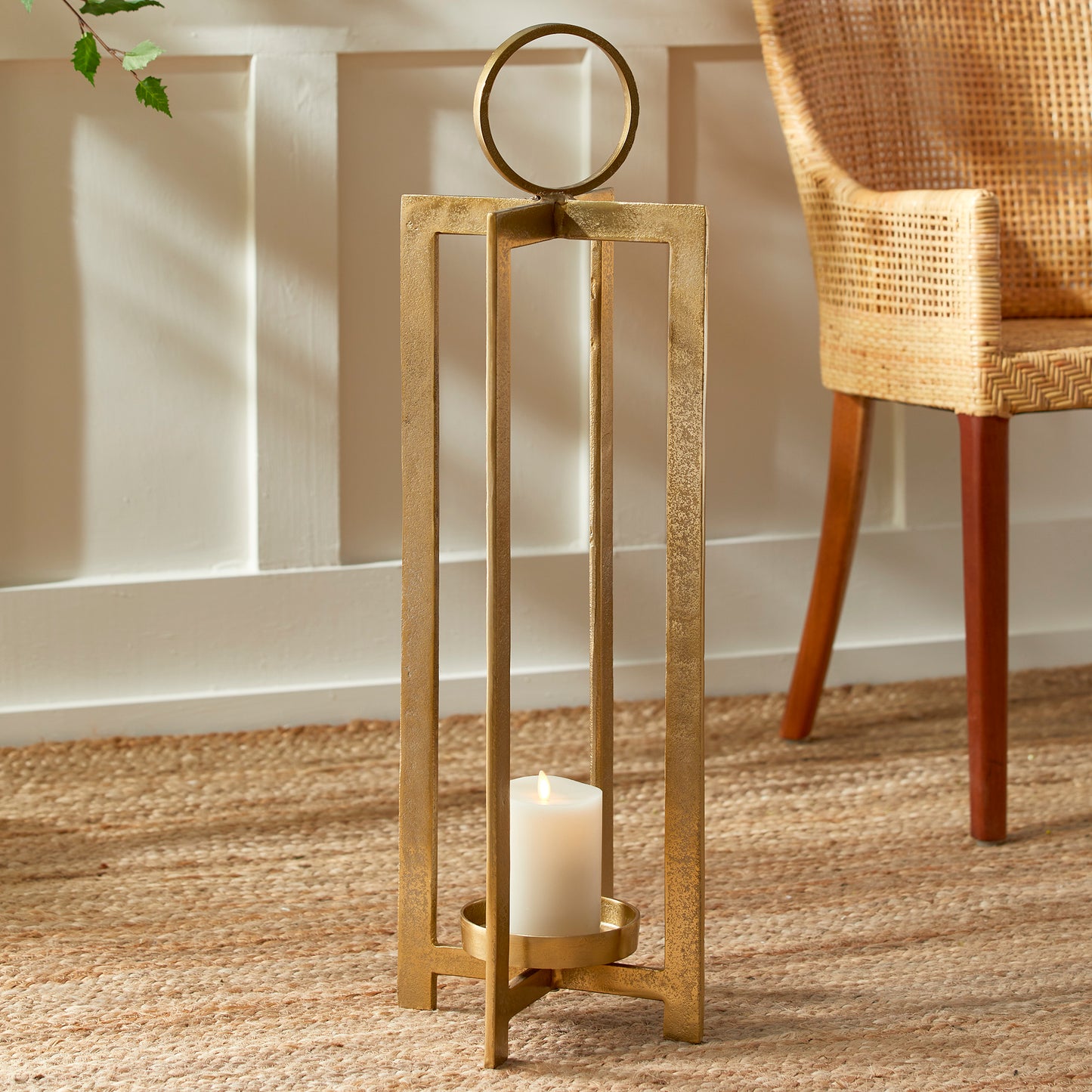 This lantern boasts a contemporary design and impressive size, commanding attention. The detailed footing raises the candle, while the spacious round handle adds an element of refinement. It would make a chic addition to a mantle, front entry, or any space. Its sleek and modern design complements any setting. The intricate footing lends an air of elegance, and the sizable round handle offers effortless portability. An ideal choice for showcasing on a mantle or in a front entryway.