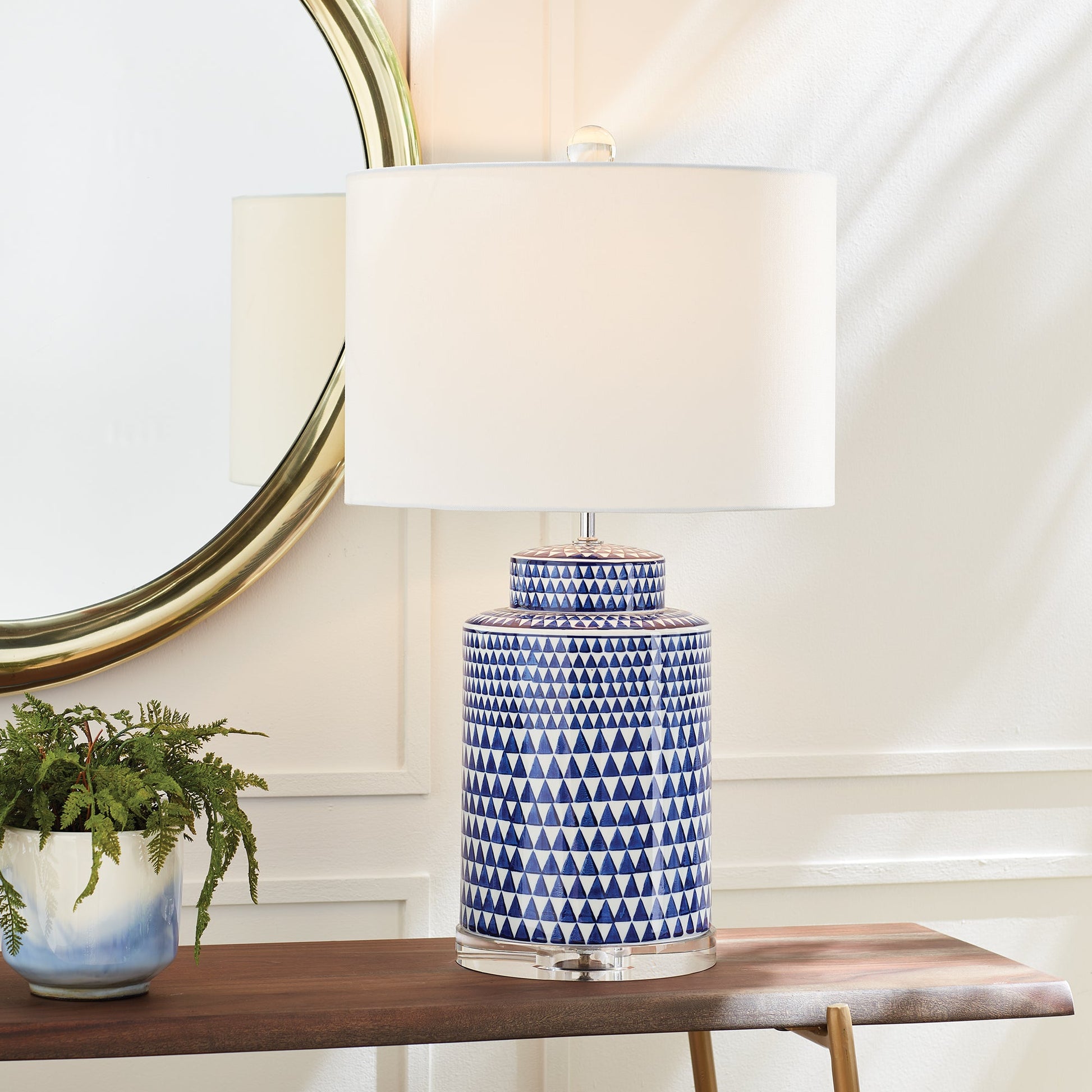 This table lamp features a traditional design in a classic blue and white ceramic ginger jar shape. Its elegant appearance adds a touch of blue to any traditional space. It also includes a crystal finial, weighs 16.5 lbs, and comes with a round shade.