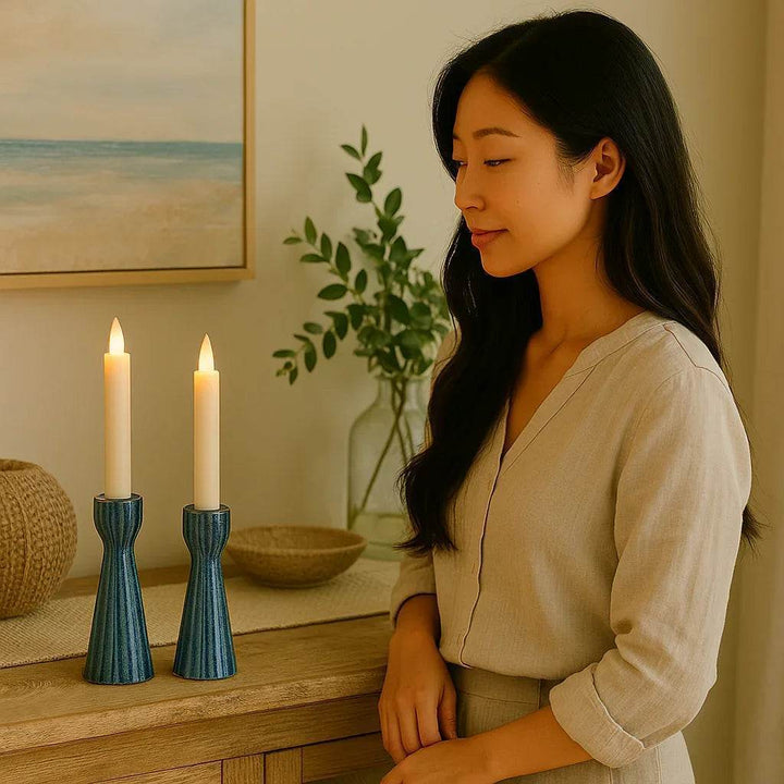 Lifestyle image - woman admiring taper candle holders on console table in natural light