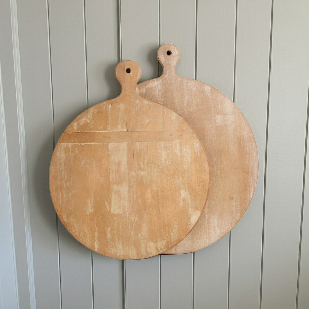Two round decorative wooden cutting boards with handles and whitewashed finish, hanging against neutral paneled wall – Farmhouse Vintage