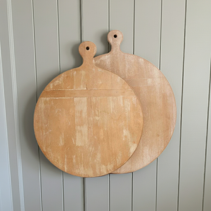 Two round decorative wooden cutting boards with handles and whitewashed finish, hanging against neutral paneled wall – Farmhouse Vintage