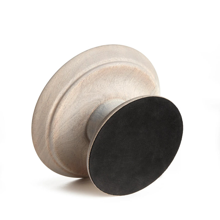 Round metallic object with two different finishes on a white background