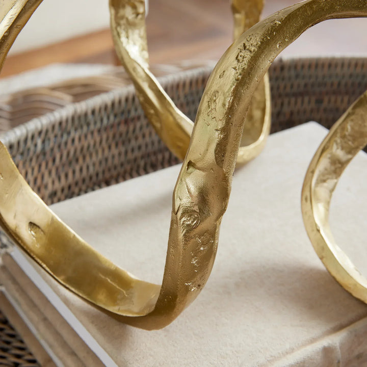 Gold decorative elements on a surface with a wicker basket in the background