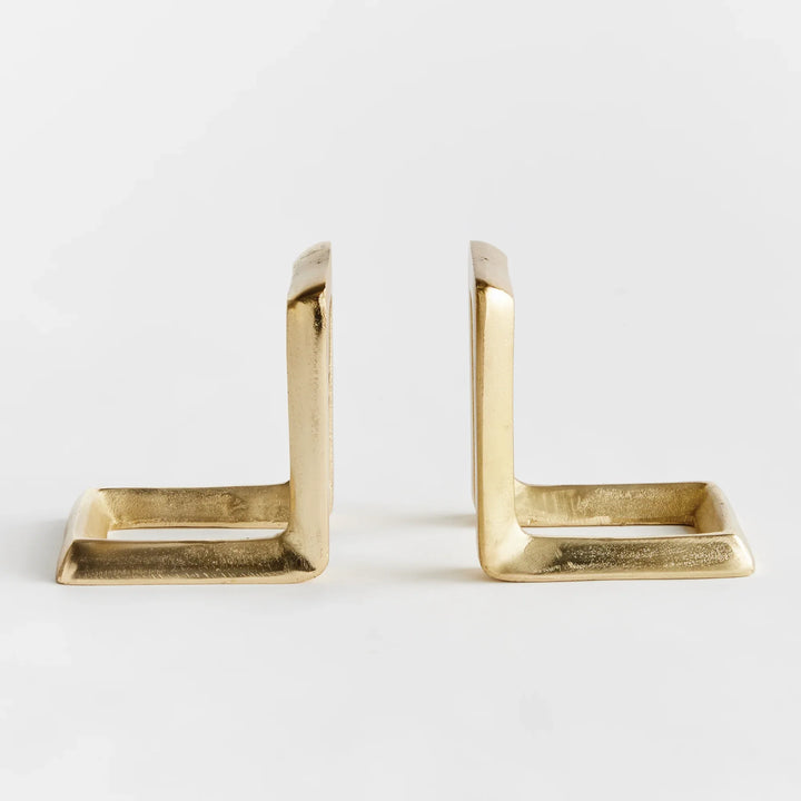 Two gold bookends on a white background
