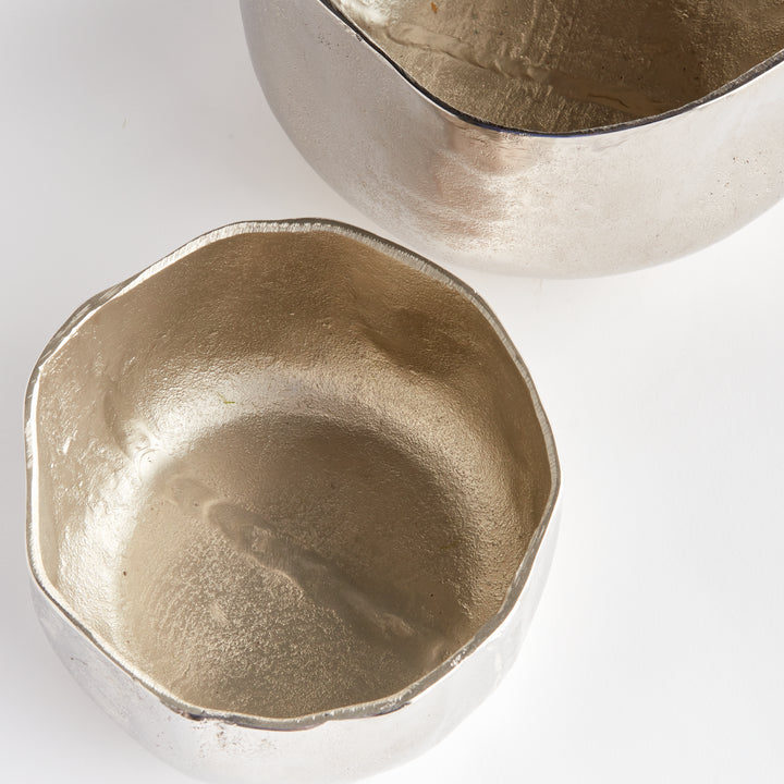 These Silver Metallic Cachepots boast an organic shape and hammered texture, lending a fresh and contemporary look to any room. Perfect for showcasing plants, these cachepots bring a touch of nature to your home in a stylish and sophisticated way.