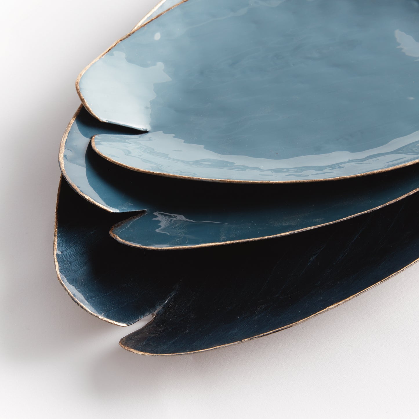 Elevate your home decor with our Camden Blue Coastal Decorative Trays. These expertly hand-painted trays feature a lily pad design and elegant gold edge detail, adding a touch of sophistication to any room. With coordinating soft blue hues, they can be used on a kitchen island, side table, or ottoman to add a pop of character. Each tray is both beautiful and functional, making them a versatile addition to any living space. Discover the charm and elegance of our hand-painted trays today.