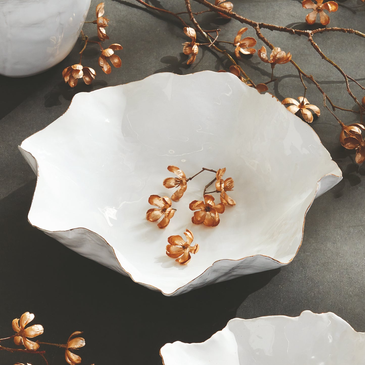 Carefully crafted with a seaside-inspired design, this large decorative tray boasts crimped edges and a natural form that is sure to make a statement in any room. Its hand-brushed gold tipped edges are electroplated for a glossy and long-lasting finish. Place it on a coffee table amongst stacked art books or on a side table for an eye-catching touch.