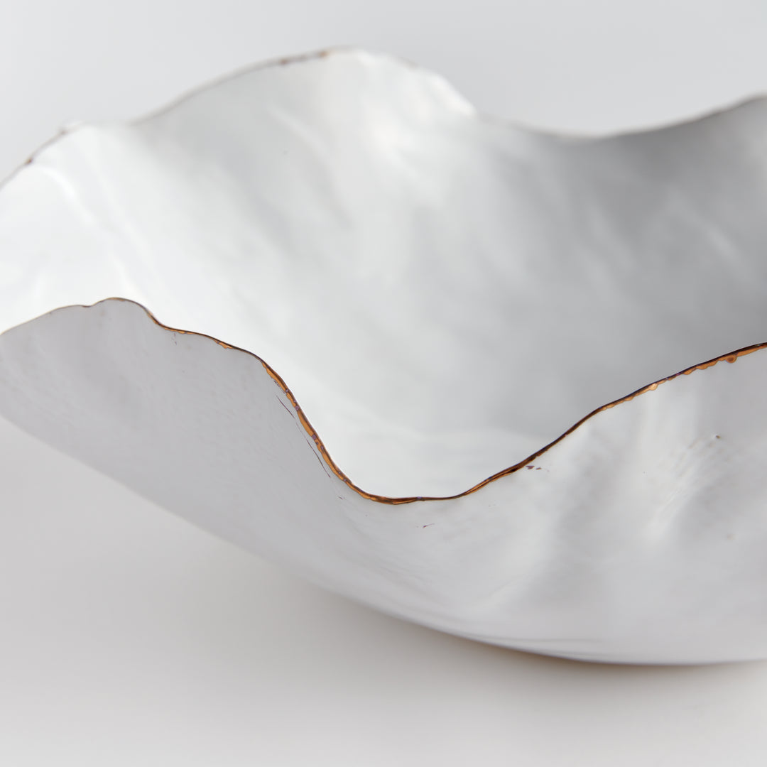 Carefully crafted with a seaside-inspired design, this large decorative tray boasts crimped edges and a natural form that is sure to make a statement in any room. Its hand-brushed gold tipped edges are electroplated for a glossy and long-lasting finish. Place it on a coffee table amongst stacked art books or on a side table for an eye-catching touch.