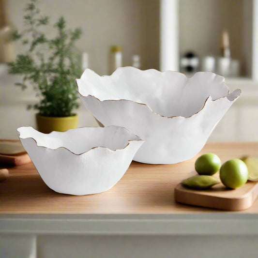 Add a touch of elegance to any room with these White Coastal Themed Decorative Bowls. The crimped edges and natural form create a stunning centerpiece, while the hand-brushed gold tipped edges add shine and durability thanks to the electroplating process. Whether displayed on a coffee table with art books or on a side table, these bowls are both functional and beautiful.