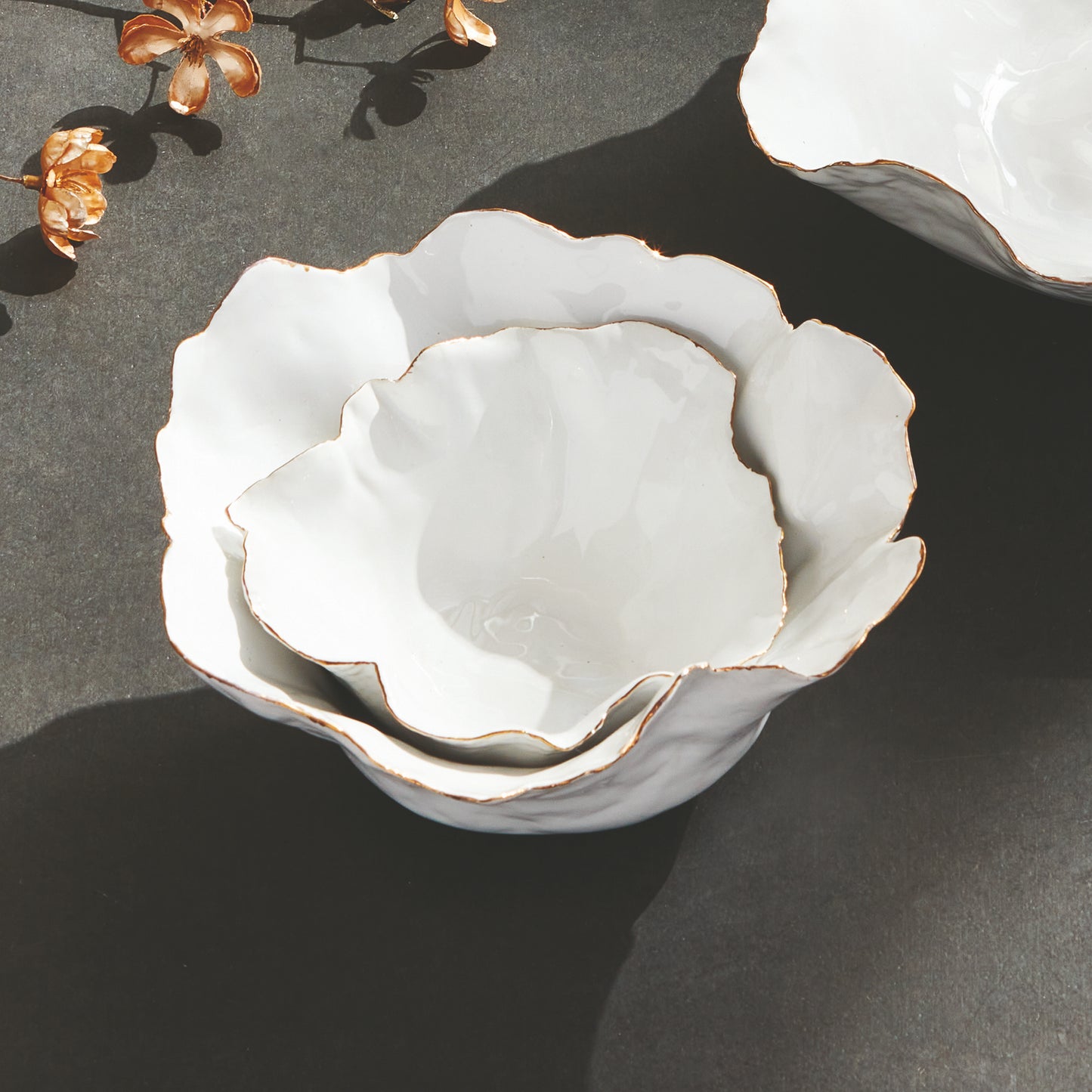 Add a touch of elegance to any room with these White Coastal Themed Decorative Bowls. The crimped edges and natural form create a stunning centerpiece, while the hand-brushed gold tipped edges add shine and durability thanks to the electroplating process. Whether displayed on a coffee table with art books or on a side table, these bowls are both functional and beautiful.