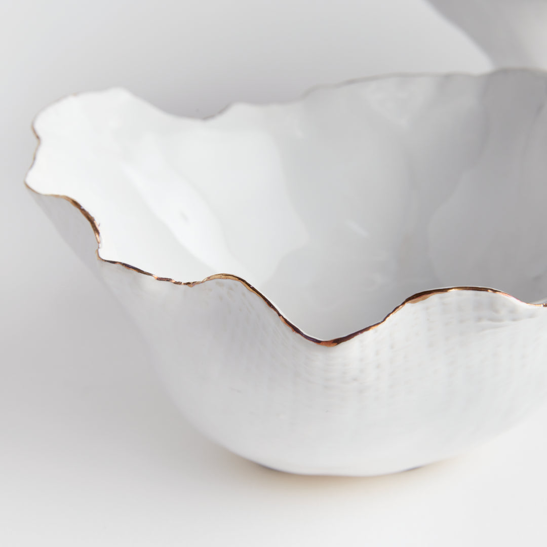 Add a touch of elegance to any room with these White Coastal Themed Decorative Bowls. The crimped edges and natural form create a stunning centerpiece, while the hand-brushed gold tipped edges add shine and durability thanks to the electroplating process. Whether displayed on a coffee table with art books or on a side table, these bowls are both functional and beautiful.