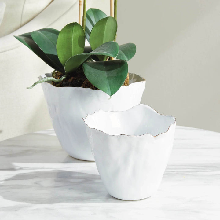 Our White Cachepots Planters feature crimped edges and a natural form, making them the perfect statement-making centerpiece. The hand-brushed gold tipped edges are electroplated for lasting shine and durability. Add your favorite orchid to elevate your home decor game.
