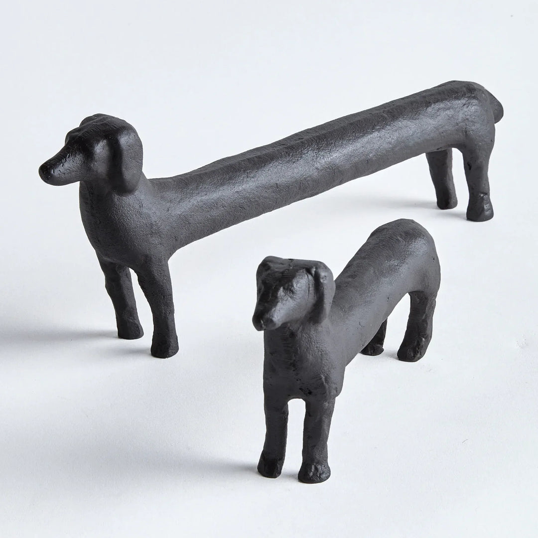 Two black dog sculptures on a white background