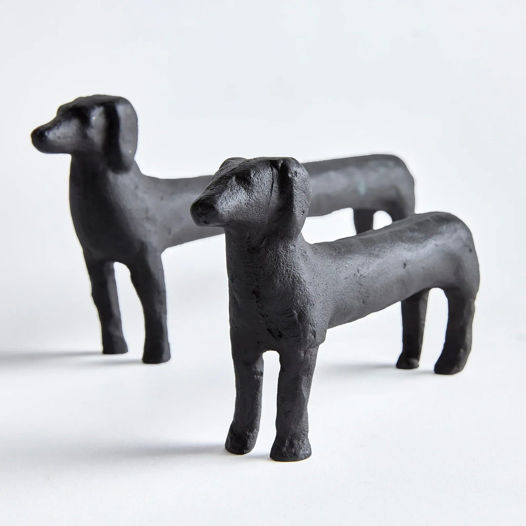 Two black dog figurines on a white background