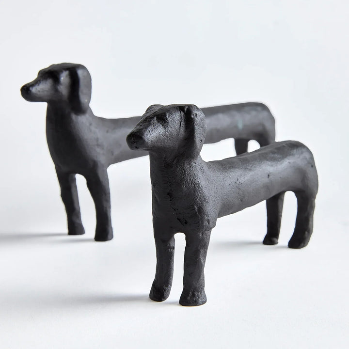Two black dog figurines on a white background