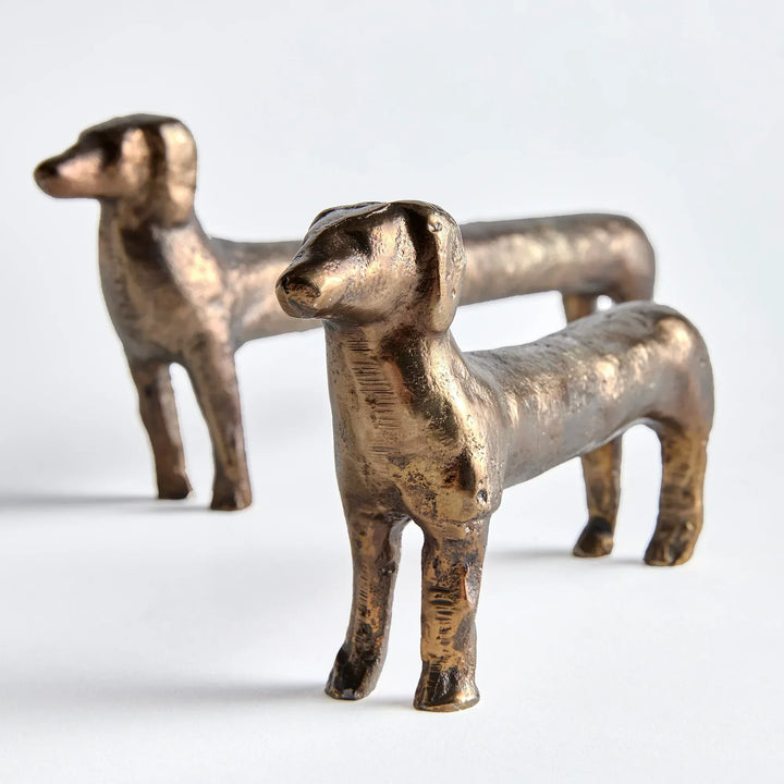 Two bronze dog figurines on a white background