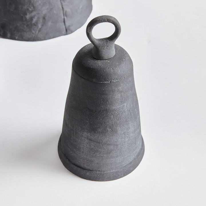 Black bell-shaped object on a white background